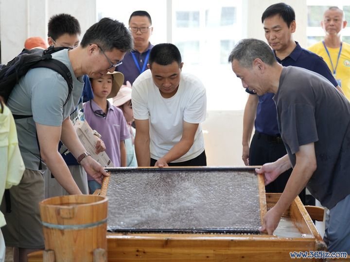 7月31日，游客在泾县中国宣纸小镇内体验宣纸制作。新华社发